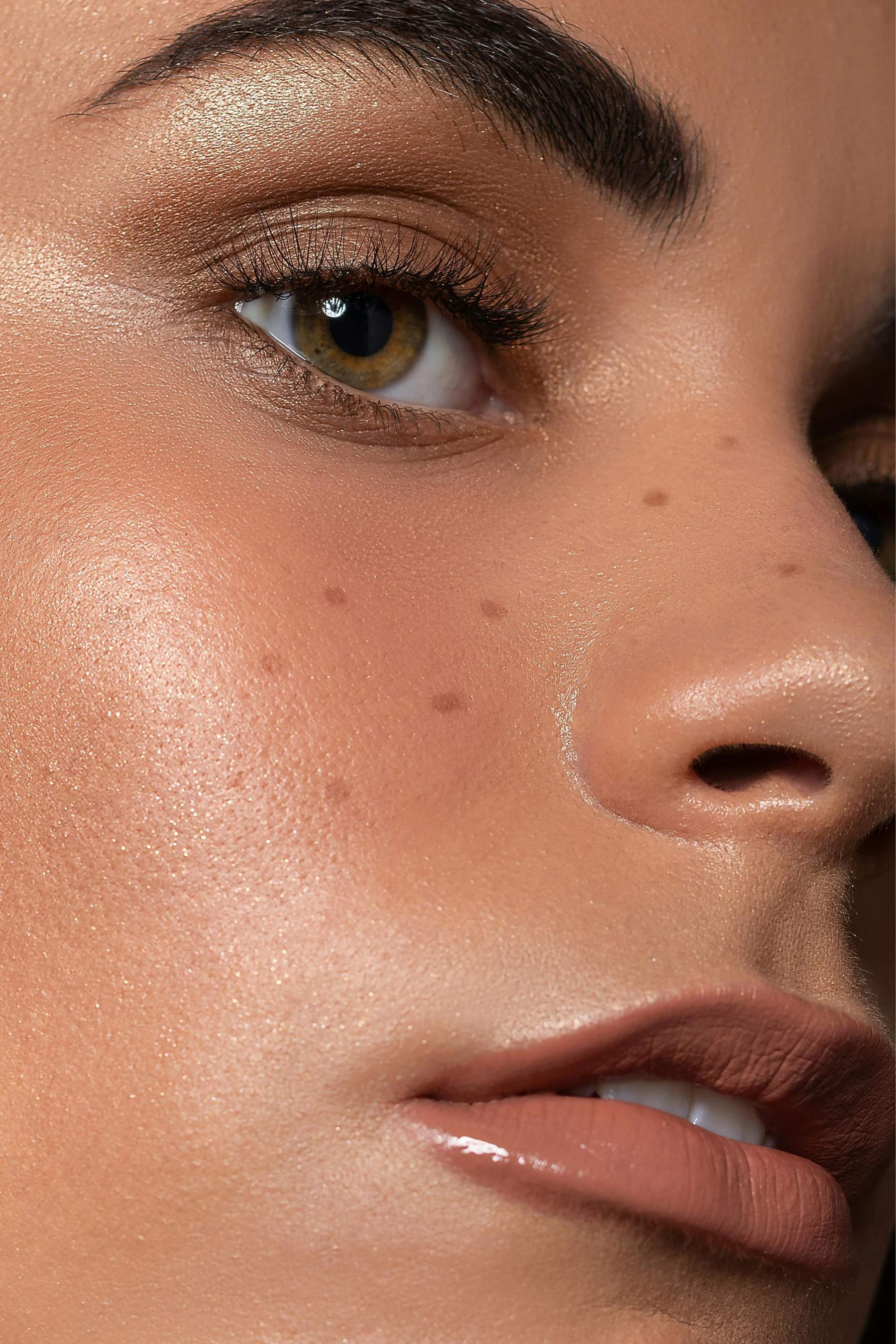 Portrait en gros plan d’une femme aux tons de peau chauds et au maquillage subtil, illustrant le type de retouche précise et réfléchie que permet la séparation de fréquences.