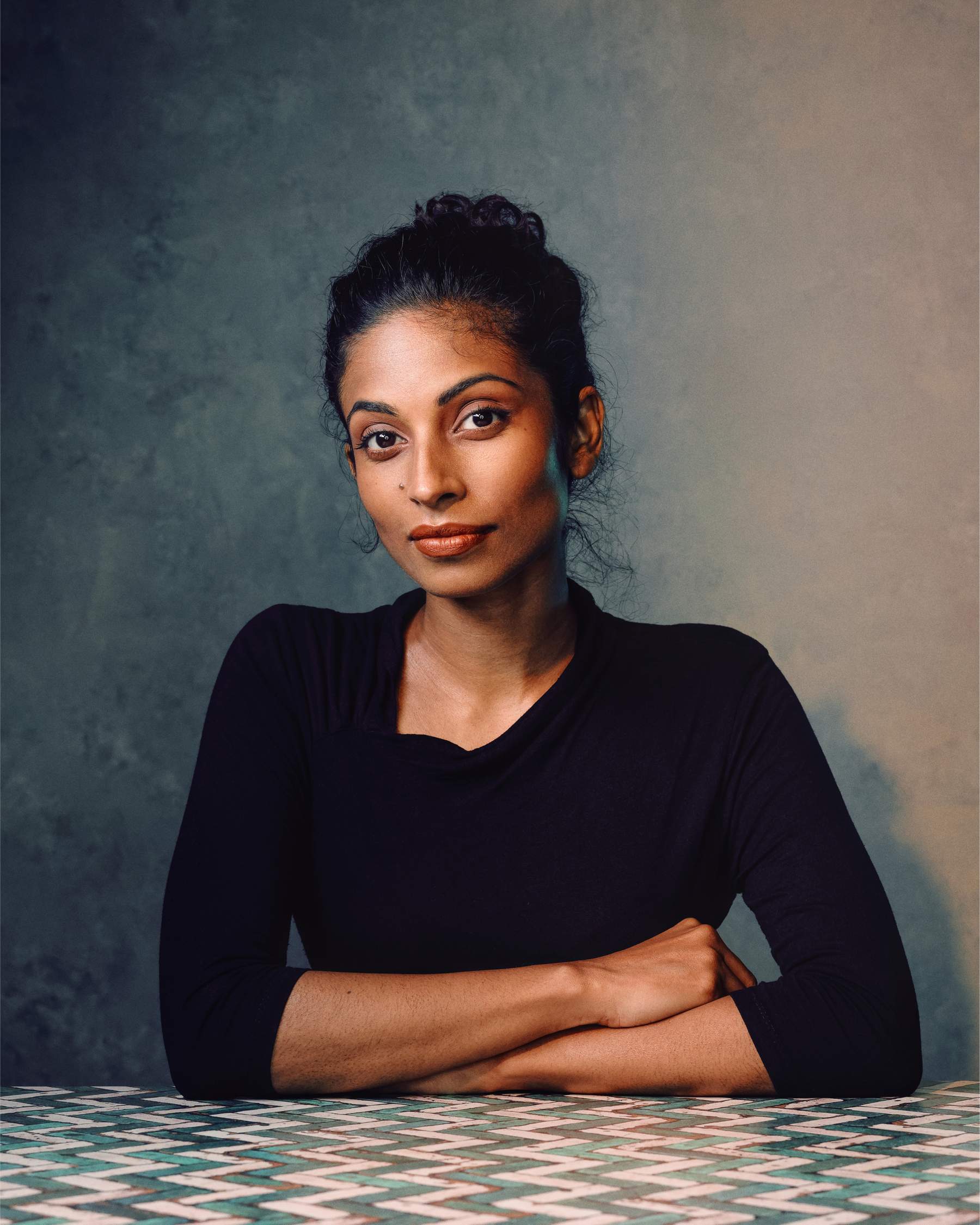 Portrait en studio d’une femme au teint uniforme et chaud sur un fond neutre.