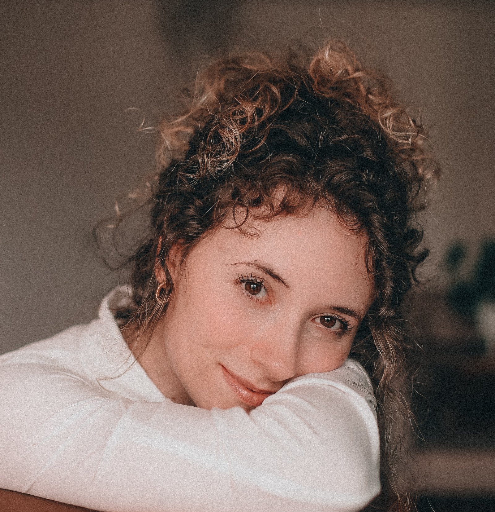 Portrait of children's book illustrator Laura Mocelin smiling warmly at the camera with her head resting on her arm