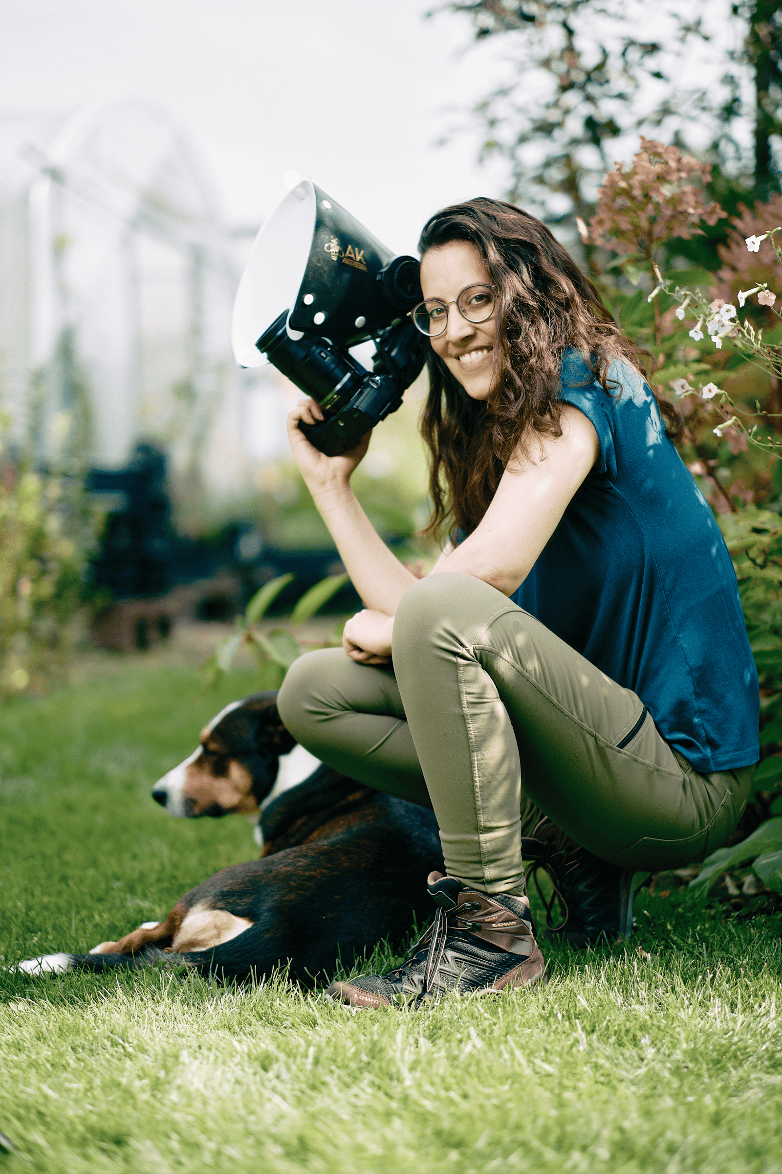 Makro fotoğrafçı Marit van Ekelenburg'un, dışarıda köpeğinin yanında otururken elinde bir kamera tutarken çekilmiş portresi.